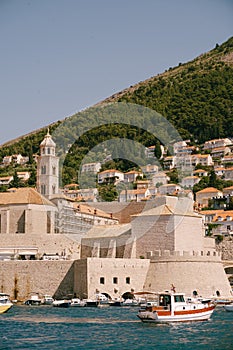 The old port harbor is porporela, near the walls of the old town of Dubrovnik, Croatia. A ship with tourists goes on an