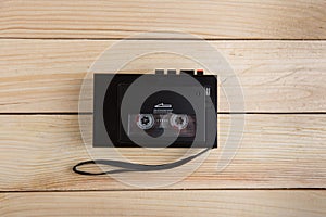 Old portable cassette player on a wooden background
