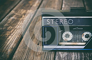 Old portable cassette player on a wooden background. image is instagram style filtered photo