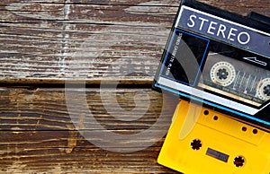 Old portable cassette player on a wooden background. image is instagram style filtered.