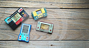 Old portable game console, Nintendo game & watch octopus and others on wooden background.