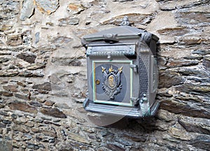 Old postbox on stone wall.