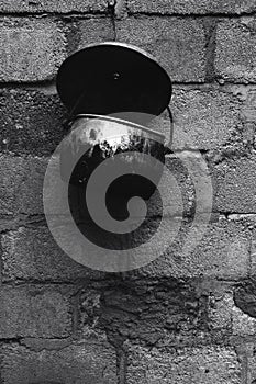 An old pot attached to a cement brick wall in Yogyakarta
