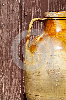 Old pot brown terracotta jar. Background old grunge wood.