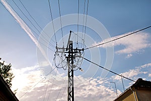 Old Power line electrical wire pillar with street feline lights against the blue sky / Wooden pole of power lines.