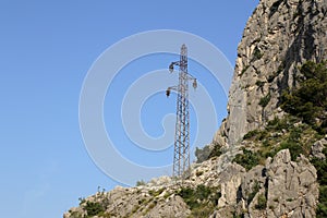 An old power mast stands in the mountains