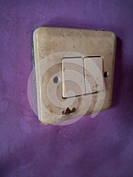 old power switch for lamp mounted on the purple wall