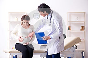 The old pregnant woman visiting young male doctor