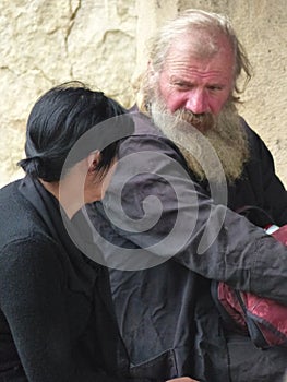 Old priest with a women in the entrance  of the orthodox monastery of Gelati in Georgia.