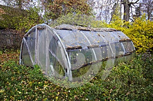 Old primitive plastic greenhouse in autumn farm garden
