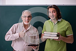 Old professor physicist and young student in the classroom