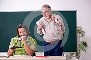 Old professor physicist and young student in the classroom