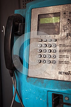 Old public blue payphone closeup, urban mood, dirty rusty buttons