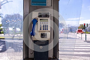 An old public telephone box located in the town of Funchal Madeira Island in Portugal on the public street on a sunny summers day