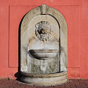 Old public water fountain with flowing water in the town hall building in Bauska, Latvia