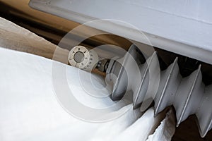 Old radiator with thermostat and the ability to reduce the heating temperature. Concept of increasing heating costs. Top