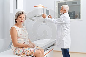 Old radiologist preparing for ultra sound session with patient.