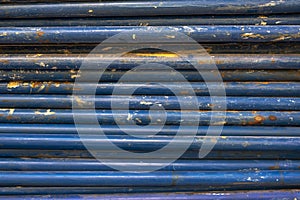 Old ragged metal rusty blue building pipes in a heap. rough surface texture