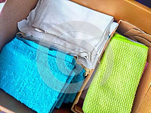 Old rags and eco-friendly cleaning cloths neatly arranged in a cardboard box. Old rags and things for cleaning and