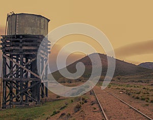 Old railroad tracks with a water tank