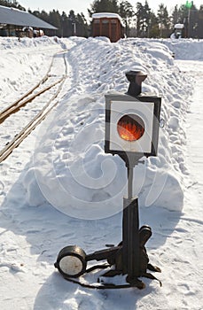 Old railway arrow with a lantern in snow