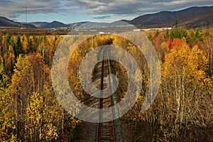 Old railway in the colorful autumn forest, view from above.