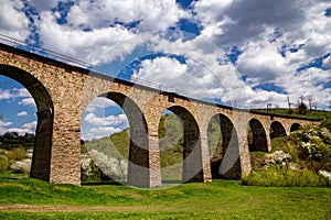 Old railway stone viaduct in the spring in sunny day photo