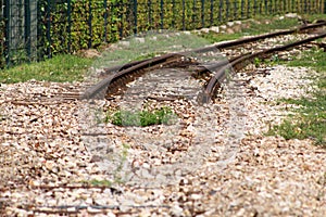Old railway track in urban city. Vintage railroad. Close view of old railroad tracks with worn ties and gravel ballast.