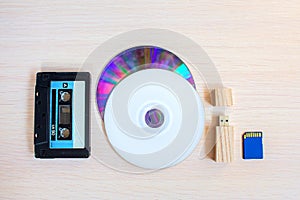 Old recorder cartridge, USB stick, and compact disks in a row