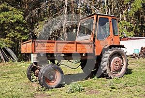 Old red agriculture tractor in farm