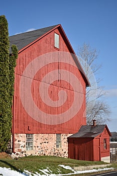 Old red barn in early winter with just a touch of snow on a sunny day on a farm