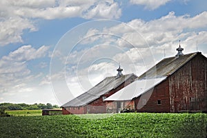 A old red barn in Illinois on a beautiful cloud filled day.