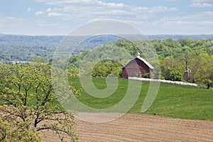 Old red barn, trees and fields in the Iowa countryside