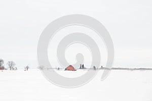A old red barn in a white winter landscape