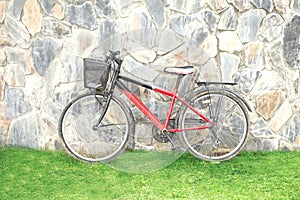 Old red bicycle leaning against a wall