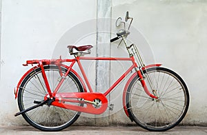 Old red bike and cement wall