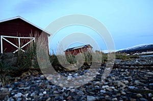 Old red boat house next to sea shore