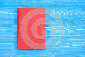 Old red book on wooden plank background. Blank empty cover for d