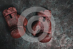 Old red Boxing gloves on a concrete background