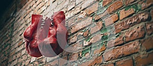 Old red boxing gloves hang on nail on brick wall with copy space for text. High resolution 3d render