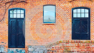 old red brick barn with wooden doors