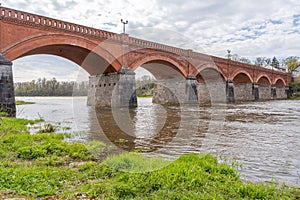 The old red brick bridge across the Venta river. Kuldiga, Latvia photo