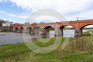 The old red brick bridge across the Venta river. Kuldiga, Latvia photo