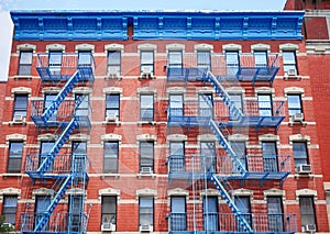 Old red brick building with blue iron fire escapes, New York City, USA