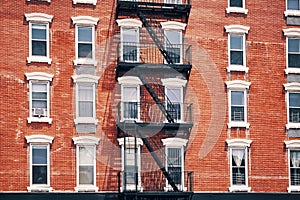 Old red brick building with fire escapes, New York City.