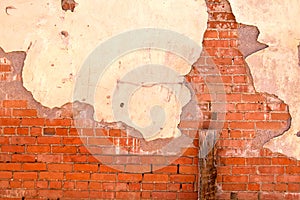 Old red brick building wall with broken plaster