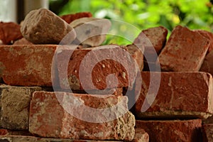 Old red brick clinker pile in te sunlight, cracked bricks