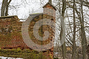 The old red brick fence is crumbling and destroyed