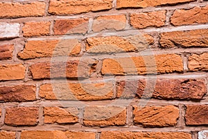 Old red brick fortress wall with gray cement mortar textute. Ancient terracotta brickwork background or pattern