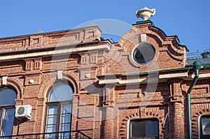 An old red brick house with a round window